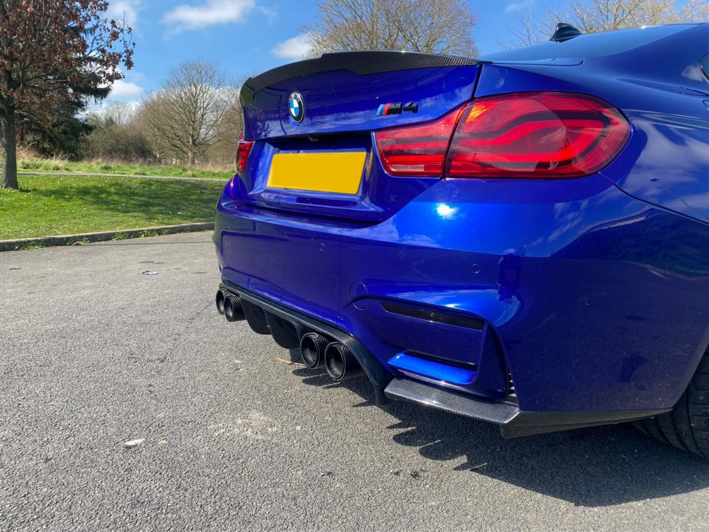 BMW M3 F80 & M4 F82 rear reflector light tint overlays in dark tint with carbon fiber diffuser and spoiler.