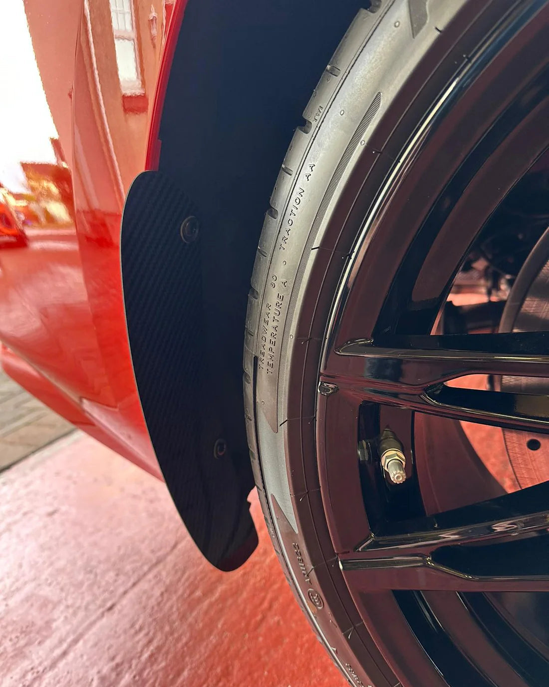 BMW M2 G87 rear arch guards mudflaps finished in carbon fiber, showing the OEM fitment uisng the original mounting points.