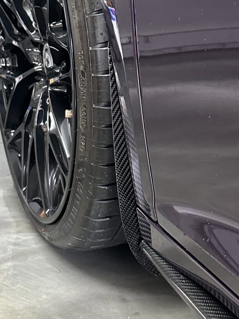 Carbon fiber and gloss black arch guard mud flaps protecting the paintwork on the vehicle from road rash, stone damage and chips.