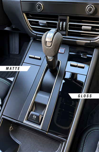 Close up of a Porsche Macan Gen 1 center console showing the difference between the matte or gloss PPF finishes. Both finishes protect the gloss black surface from scratches and eliminate fingerprints.